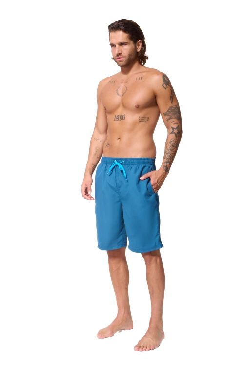 Niebieskie szorty kąpielowe męskie ZAGANO 5146-MIDNIGHT BLUE z elastycznym pasem, jasnoniebieskim sznurkiem do regulacji oraz bocznymi i tylną kieszenią. Klasyczny, dłuższy fason z subtelnym logo marki, idealny na basen, plażę i do pływania.