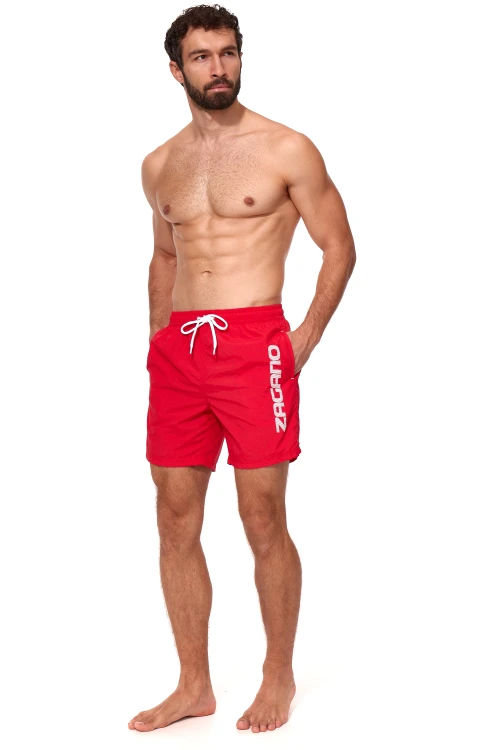 Czerwone długie szorty kąpielowe męskie ZAGANO 5115 LONG-RED z białym sznurkiem do regulacji i dużym pionowym logo marki na nogawce. Wygodny, sportowy fason z bocznymi kieszeniami i tylną kieszenią z klapką, idealny na basen, plażę i do pływania.